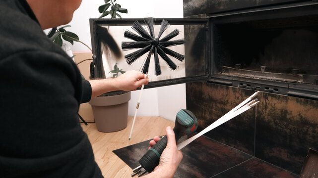 Technician assembling a rotary brush head beside a fireplace